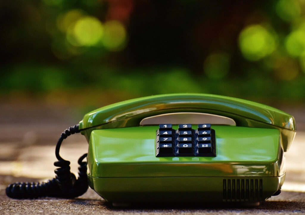 Green vintage landline telephone on a desk